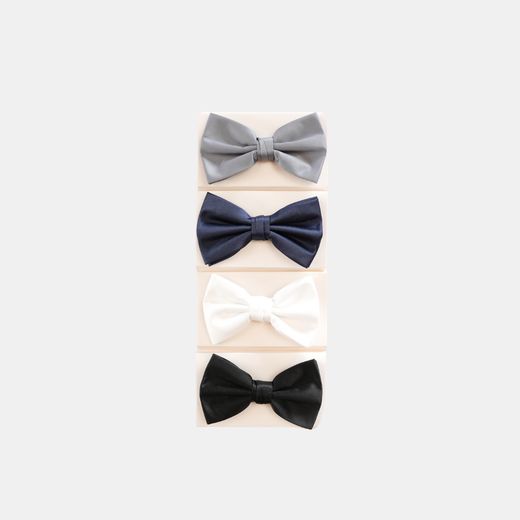 Four bow ties stacked: silver, navy, white and black