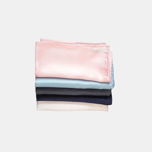 A folded stack of pocket handkerchiefs in pink, light blue, navy, black and ivory