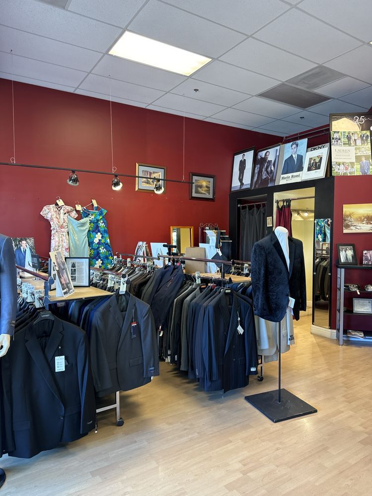 The showroom: racks of suits and sport coats, mannequins, and red walls hung with framed photos